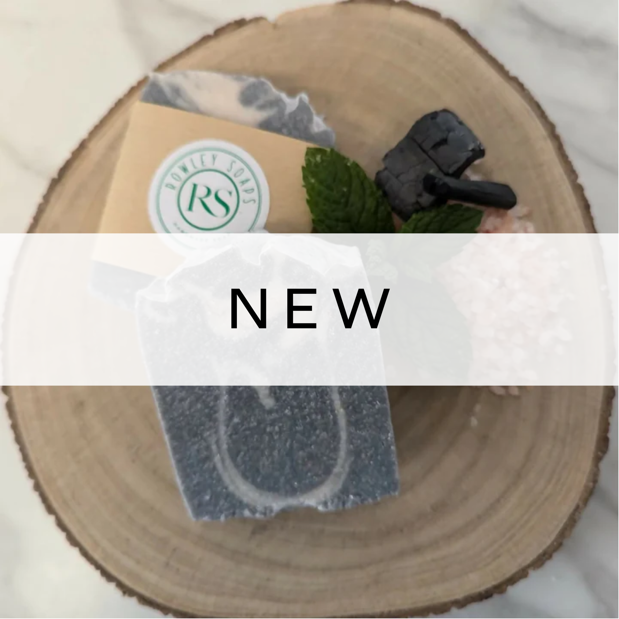 Grey and white handcrafted soap bars displayed on a neutral background.