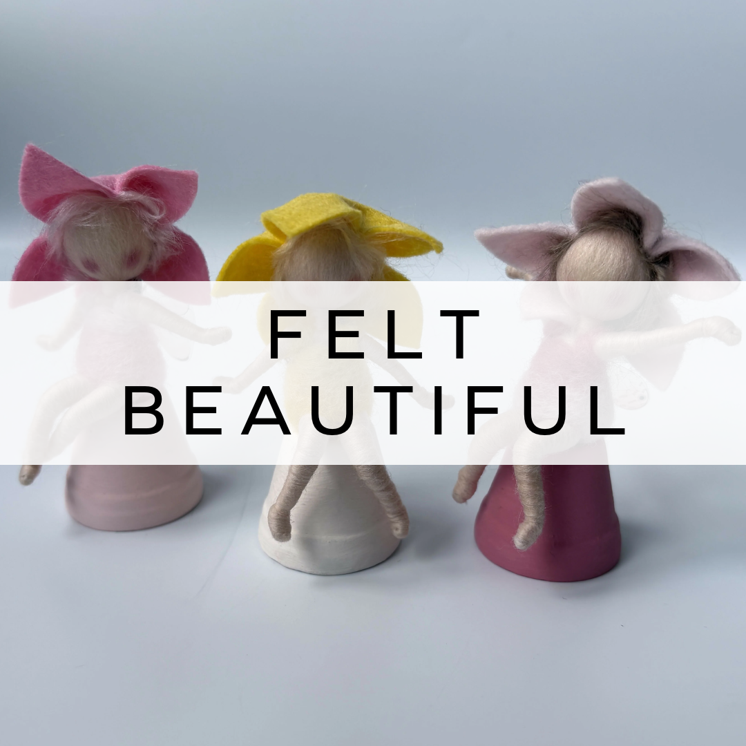 Felt fairies on stands in different colours.