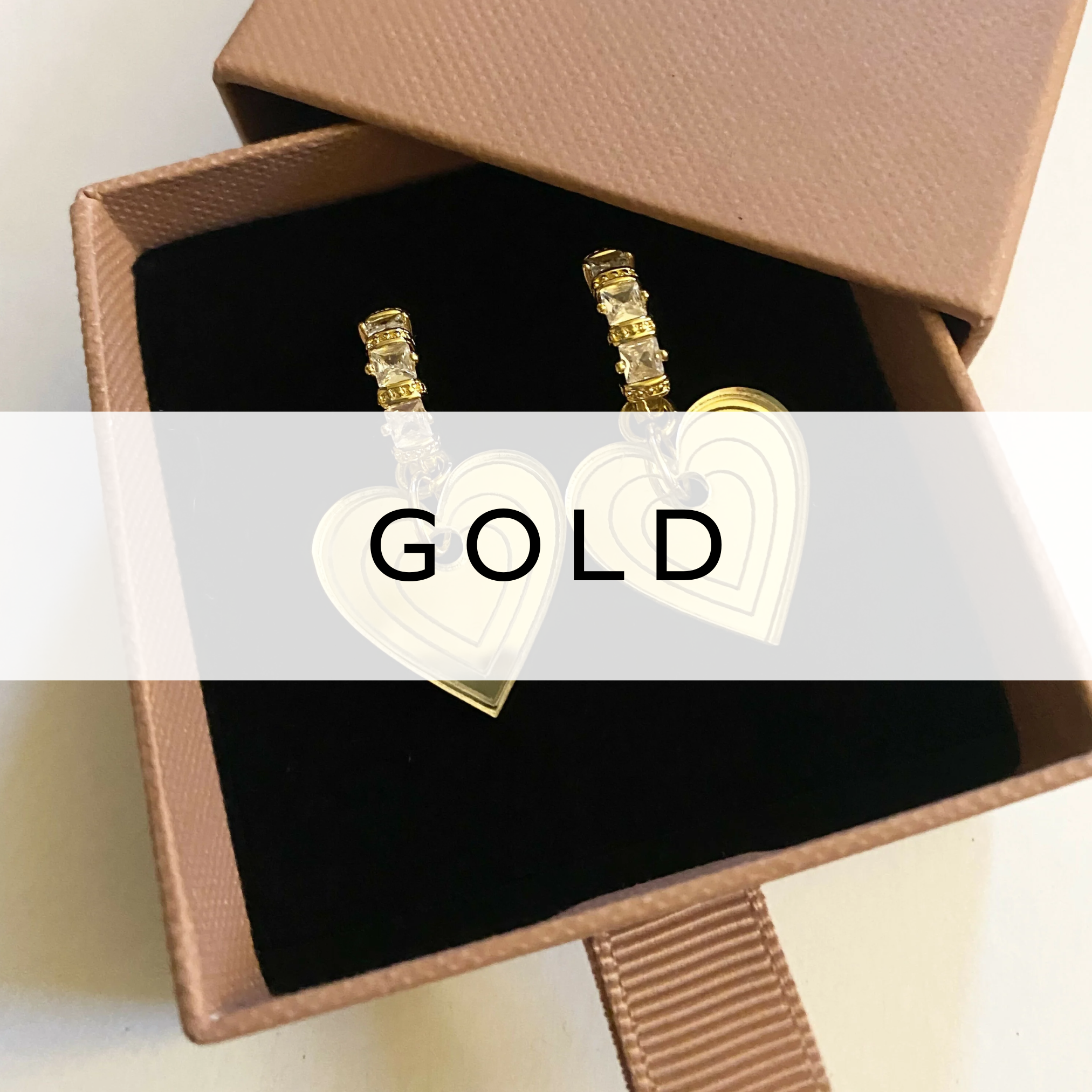 Gold hoop earrings with hanging heart charms – elegant and romantic accessory.