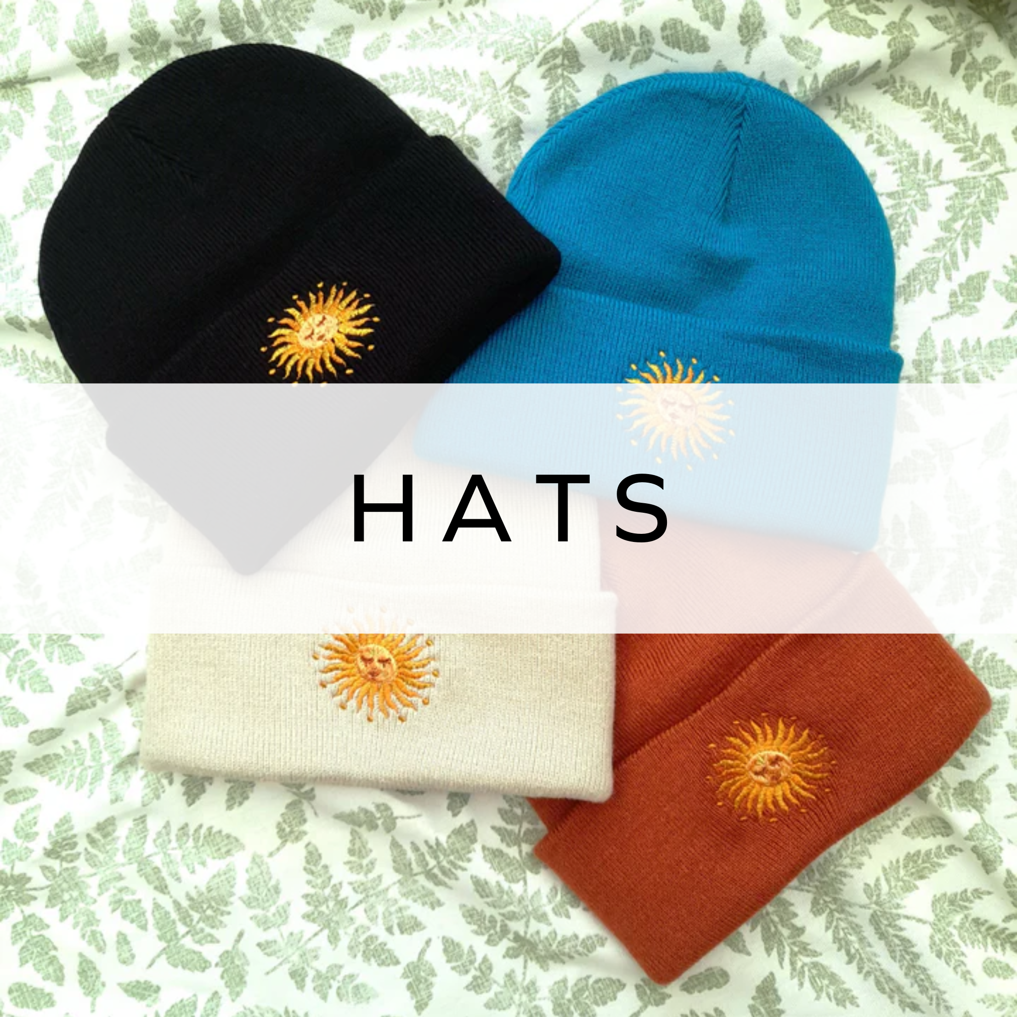 A set of beanies in black, white, orange, and blue featuring a sun design, perfect for adding a pop of colour and warmth to your winter wardrobe.