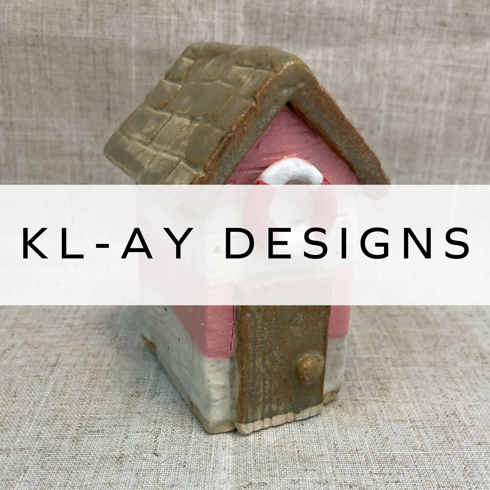 Ceramic beach hut with white and blue horizontal stripes and a life ring above the door, capturing a coastal vibe.