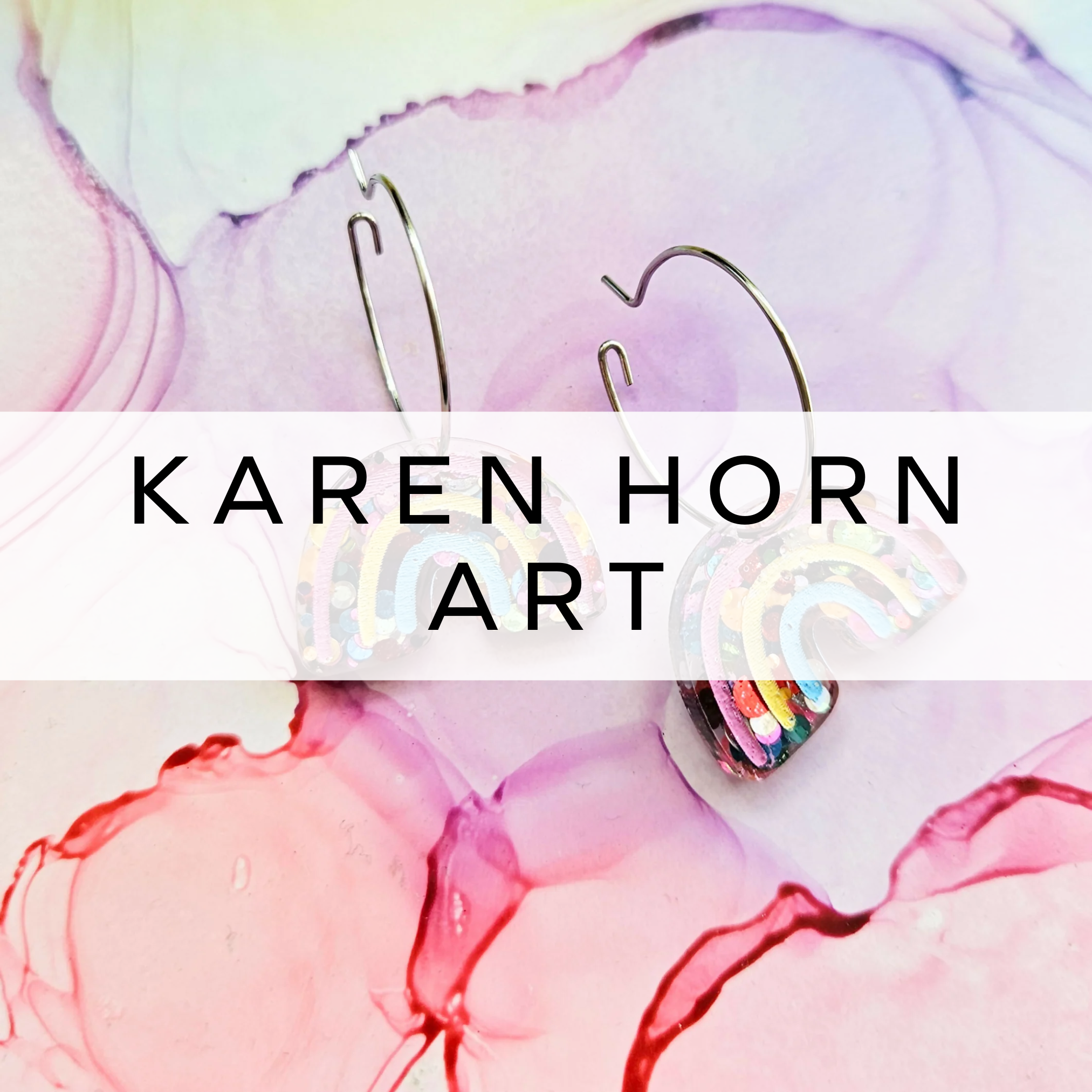 Glittery rainbow drop earrings on marble background.