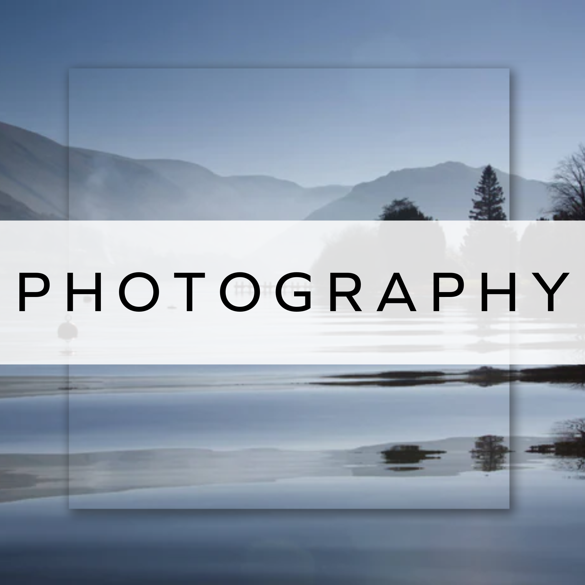 A photograph of a calm lake with mountains behind.