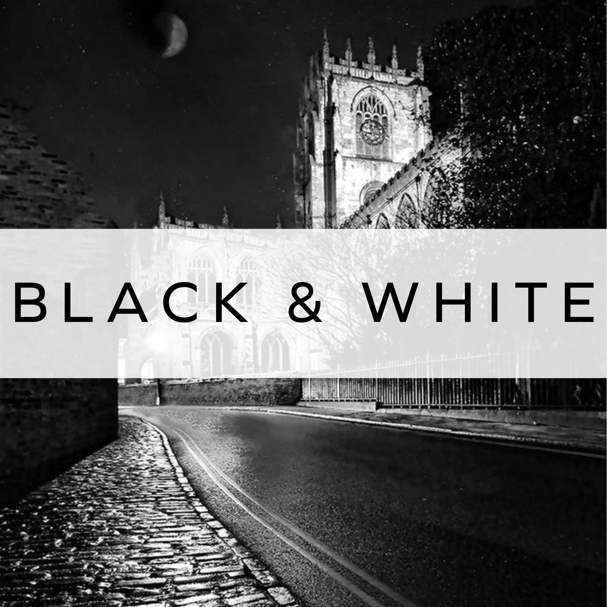 Black and white photograph of a church at night, with dramatic shadows and soft lighting creating a moody, atmospheric scene.