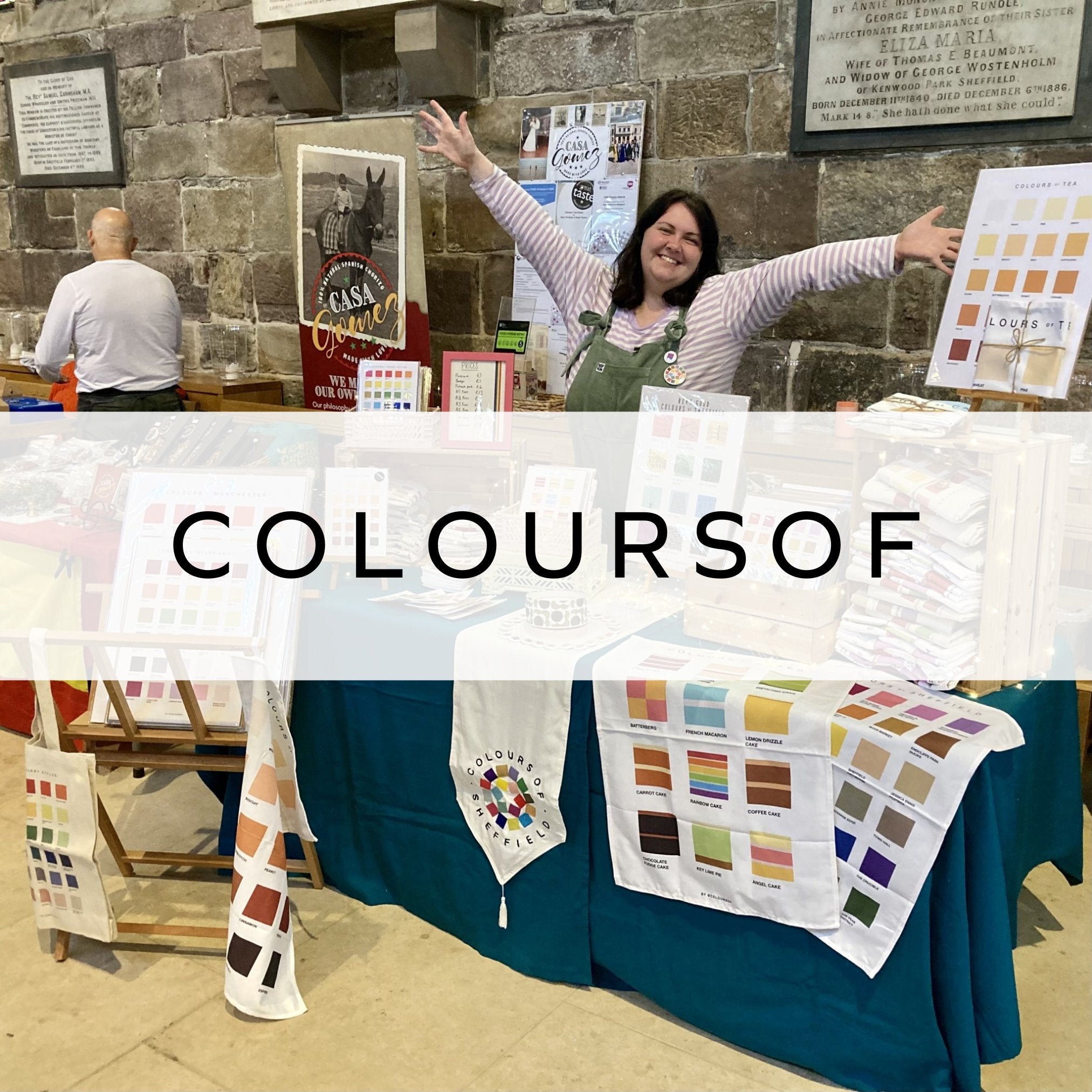 A vibrant market stall adorned with a collection of colourful Pantone art prints, showcasing custom colour matches and unique designs in a lively display.