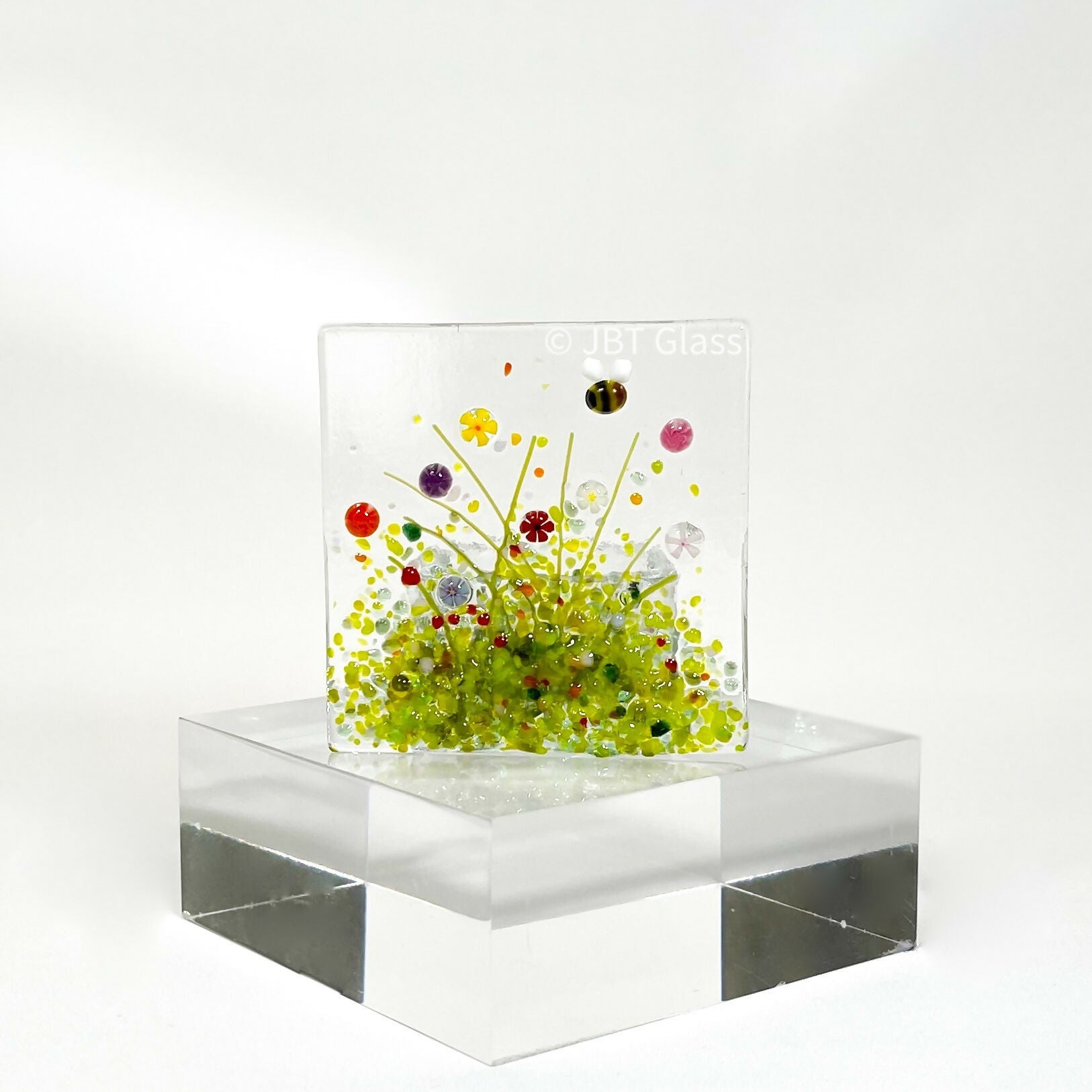 Glass tealight holder with floral design.