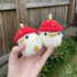 Two crochet ducks with strawberry hats.