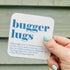 White coaster with blue 'Buggerlugs' definition typography.