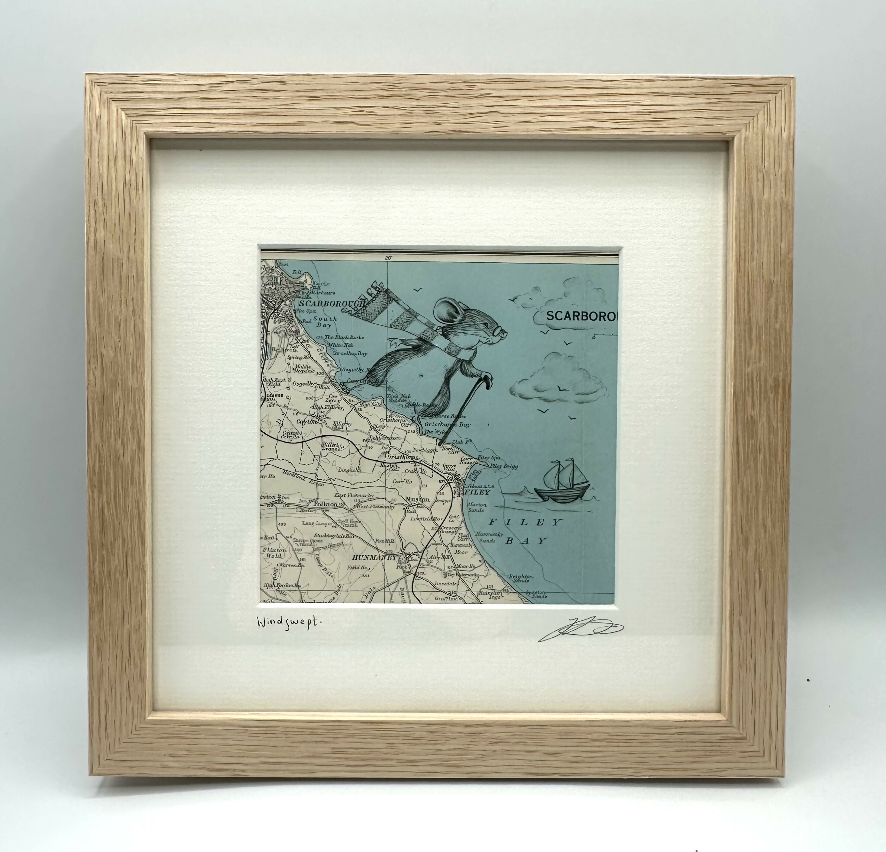 Pen drawing of a mouse climbing on the coast of an original map of Scarborough and Filey, framed.