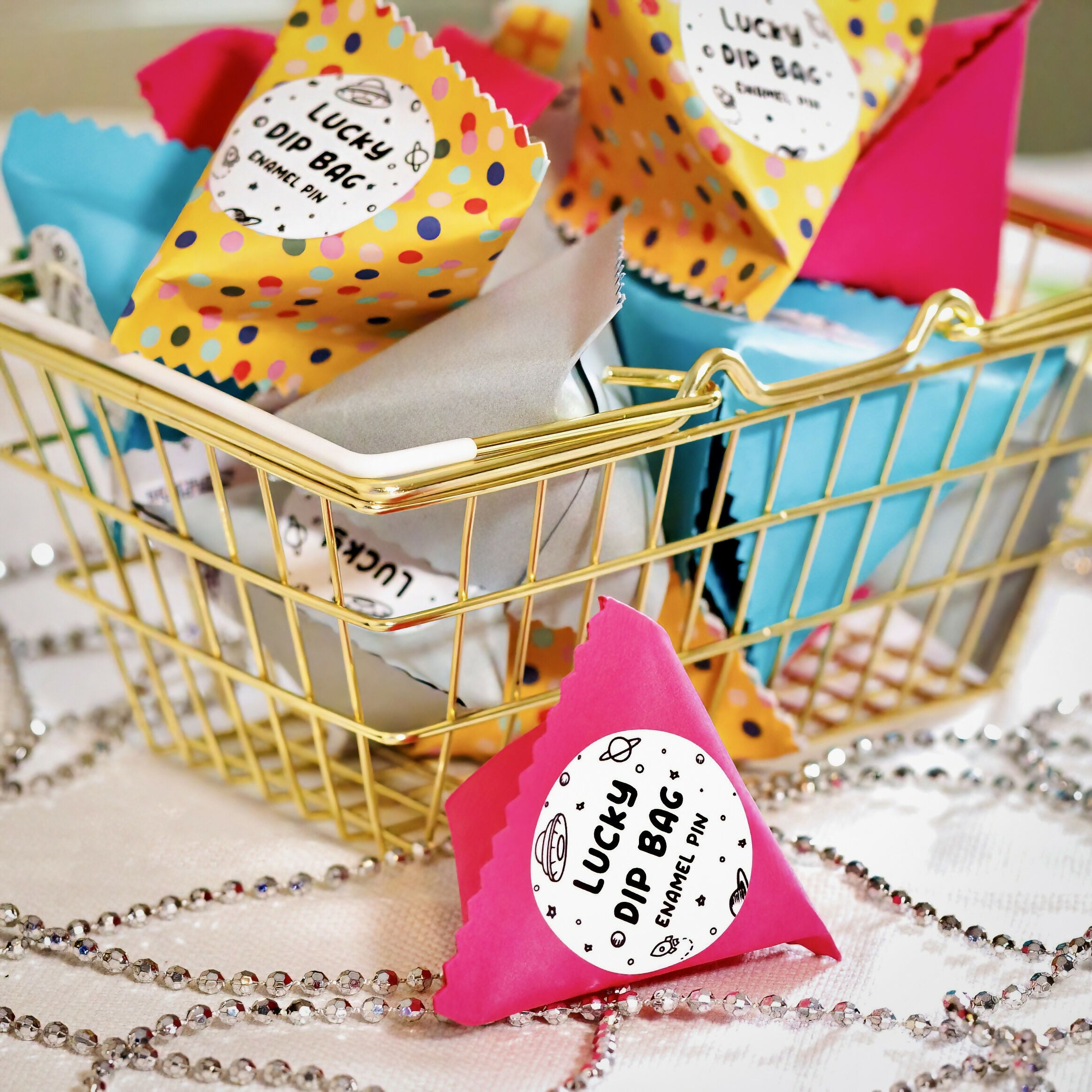 Colourful lucky dip bags in a gold basket.