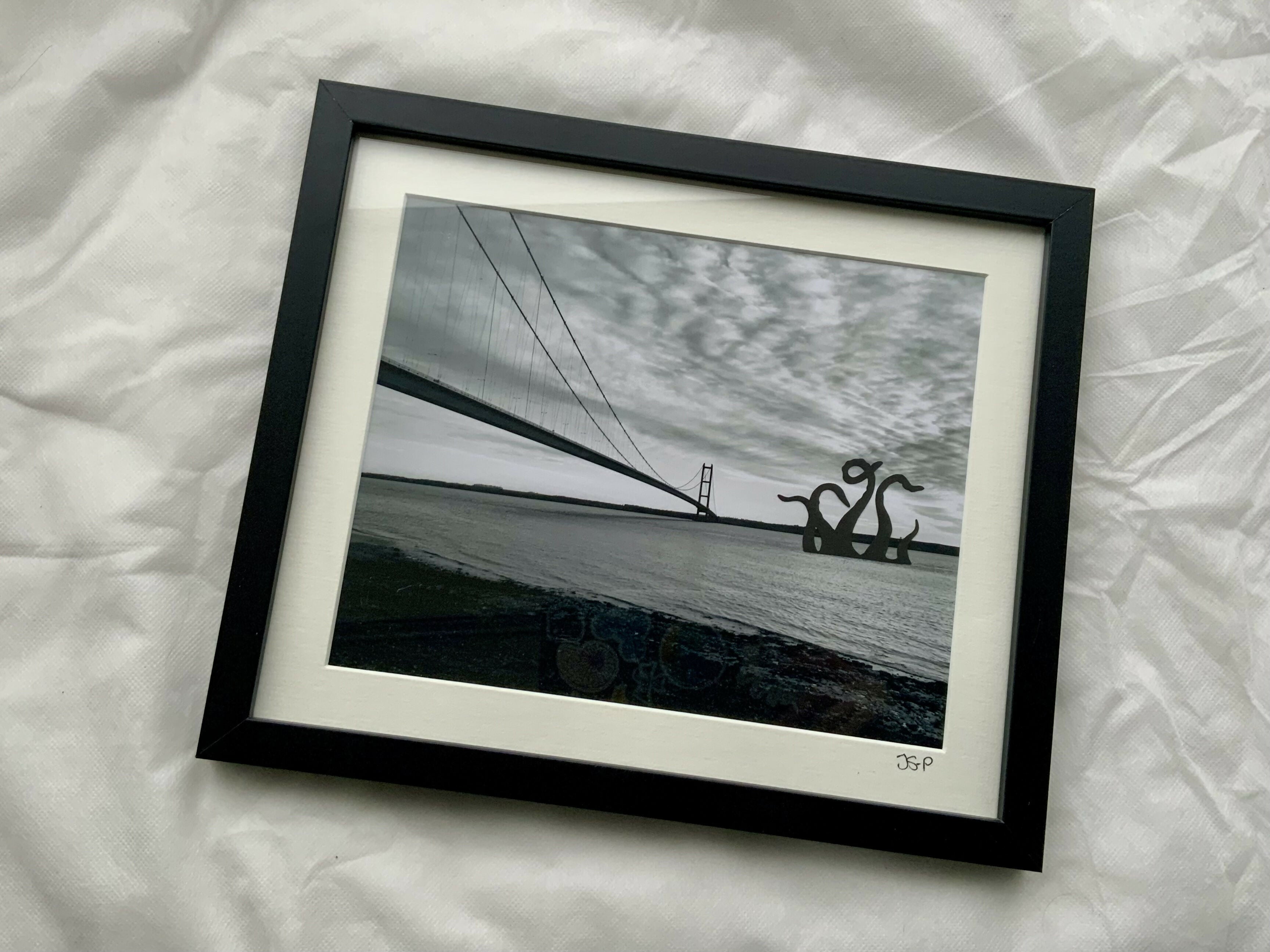 Black and white image of the Humber Bridge and a Kraken in the water.