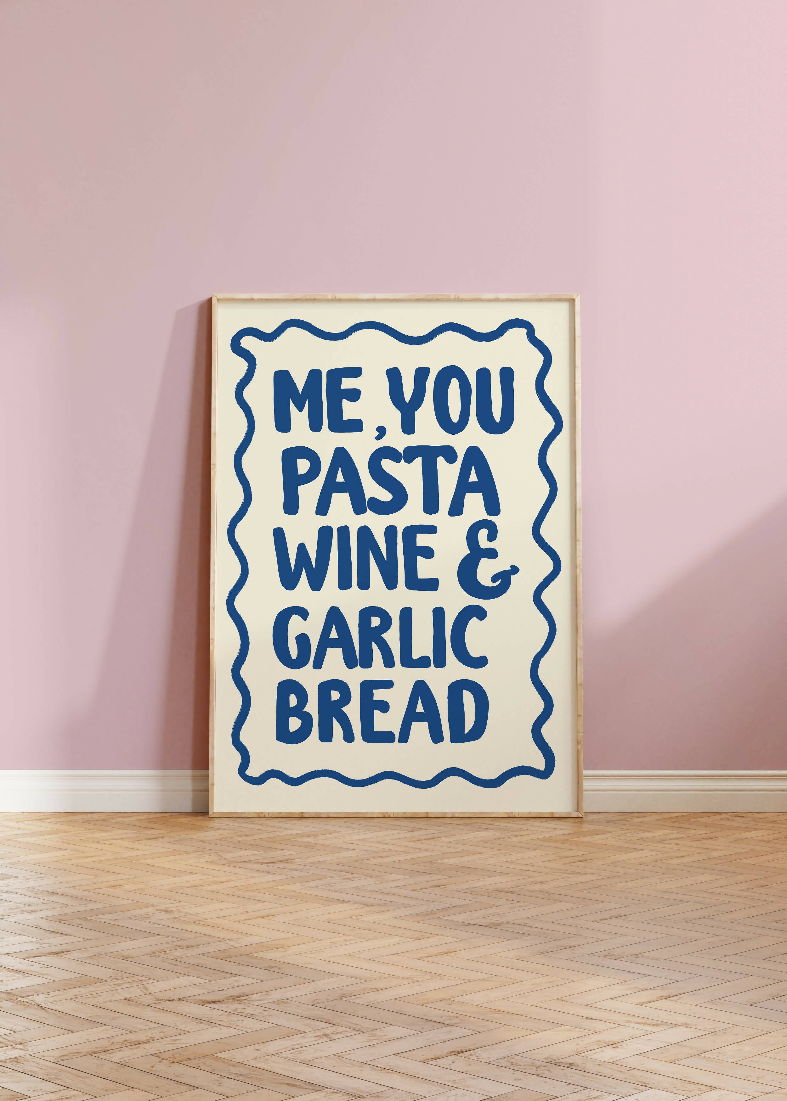 Blue typography print displayed against a pink wall.