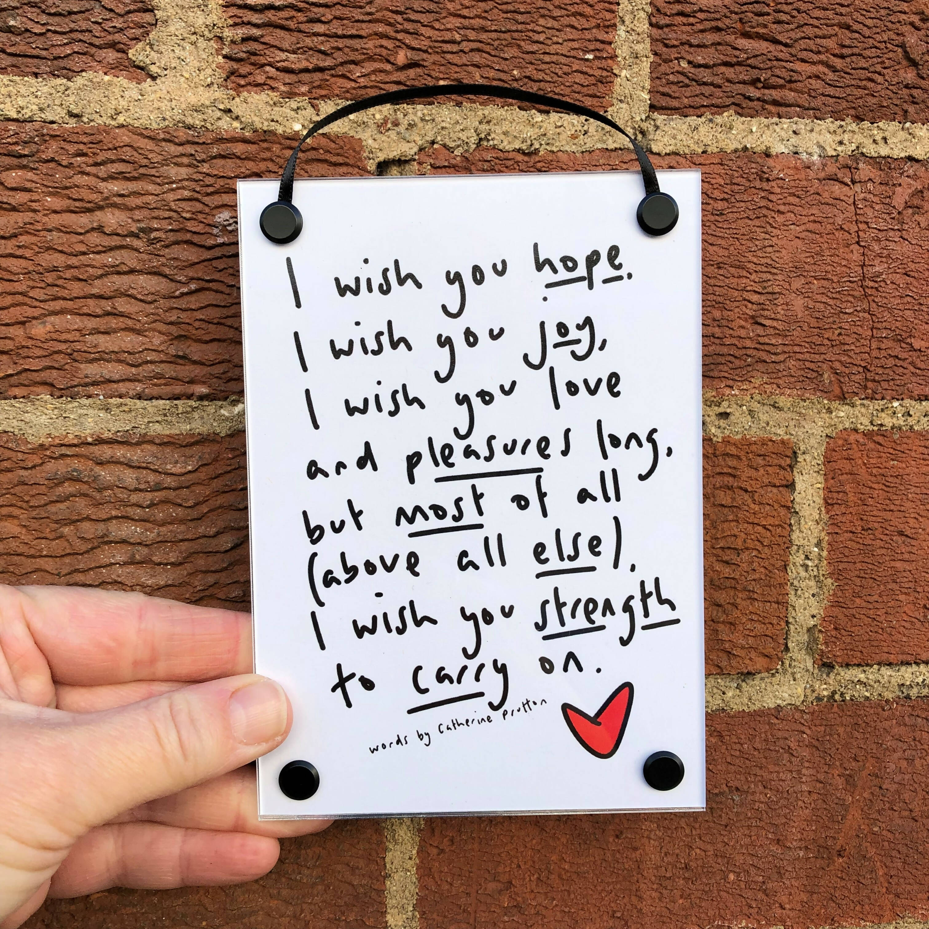An A6 hanging poem in black and white with a red love heart.