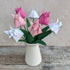bouquet of seven origami tulips in pinks and white with green paper leaves