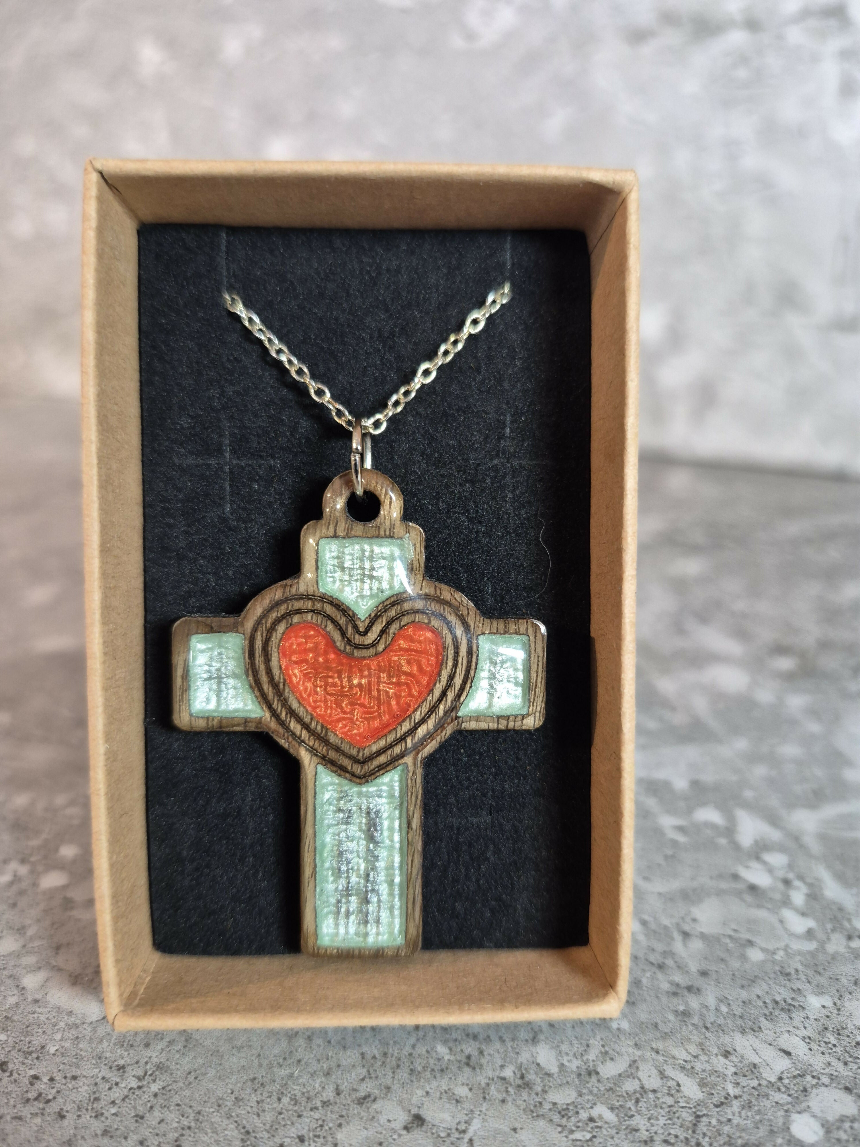 Handcrafted and engraved walnut veneered cross with a heart pendent.