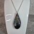 Unique, Hand Crafted, Teardrop Pendant Showing Black Silhouetted Pine Trees Against a Multicoloured Abstract Back Ground Sky