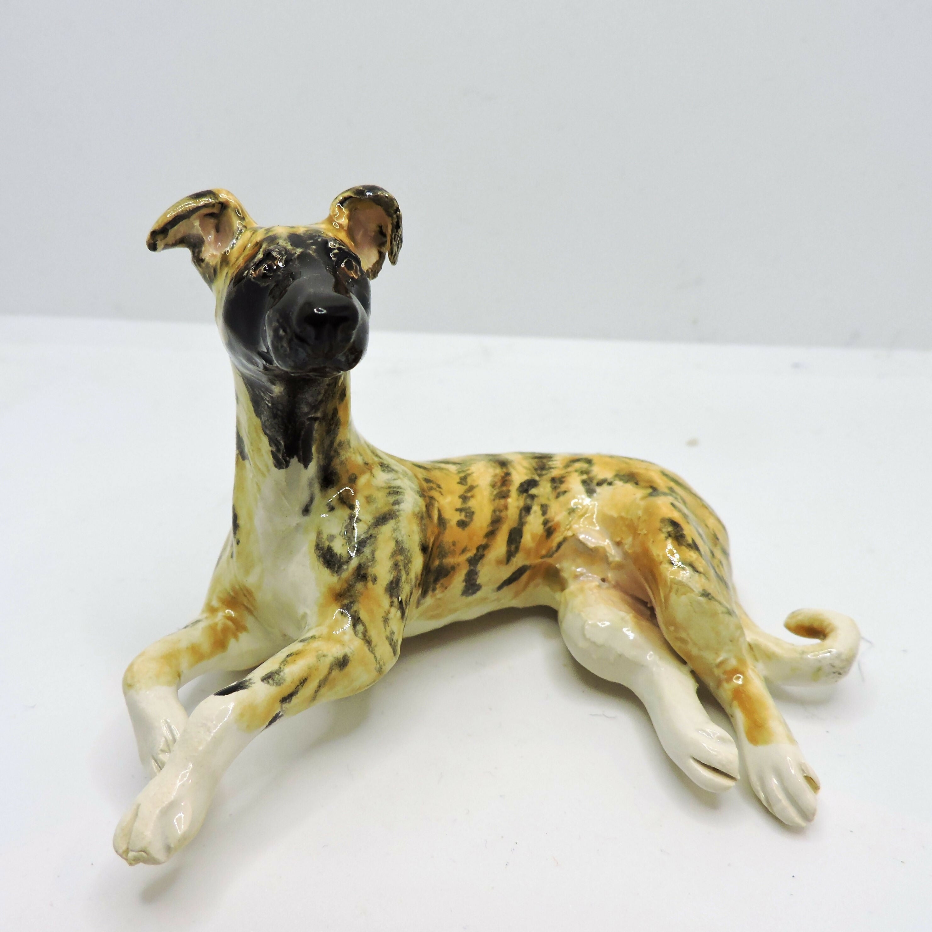 Ceramic lying Whippet dog sculpture, Black mask Brindle