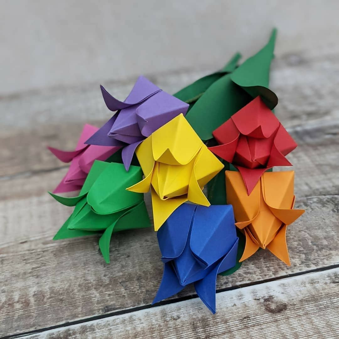 bouquet of seven origami tulips in rainbow colours with green paper leaves