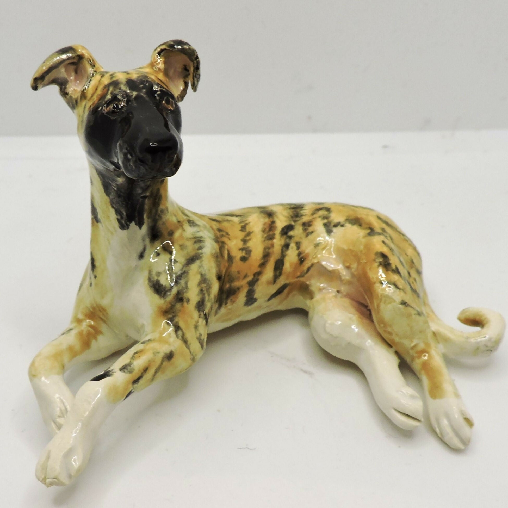 Ceramic lying Whippet dog sculpture, Black mask Brindle