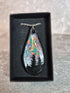 Unique, Hand Crafted, Teardrop Pendant Showing Black Silhouetted Pine Trees Against a Multicoloured Abstract Back Ground Sky