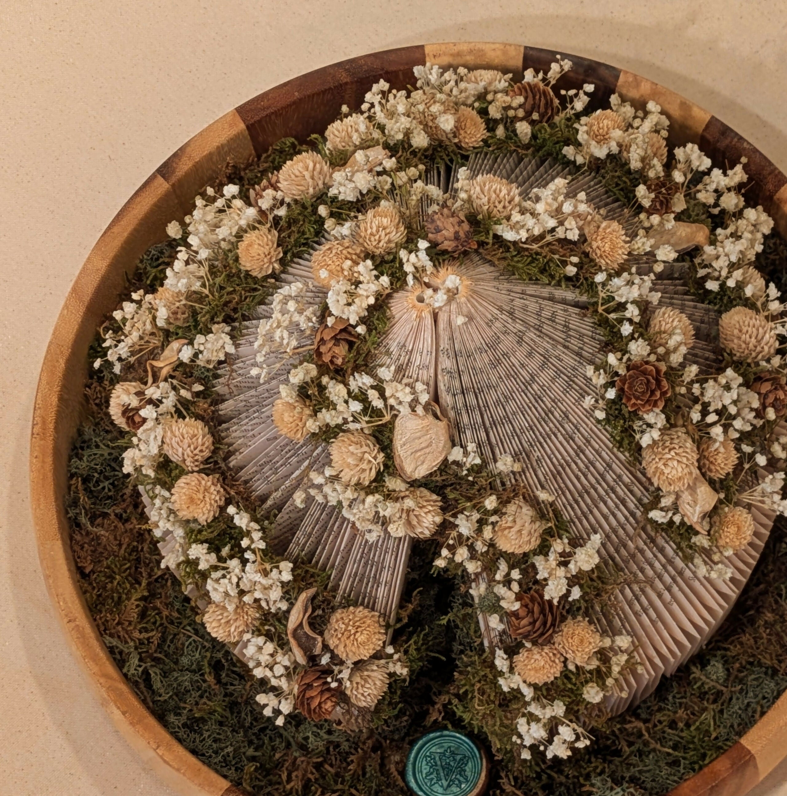 Warm Floral Arrangement on Circular Book in Wooden Tray