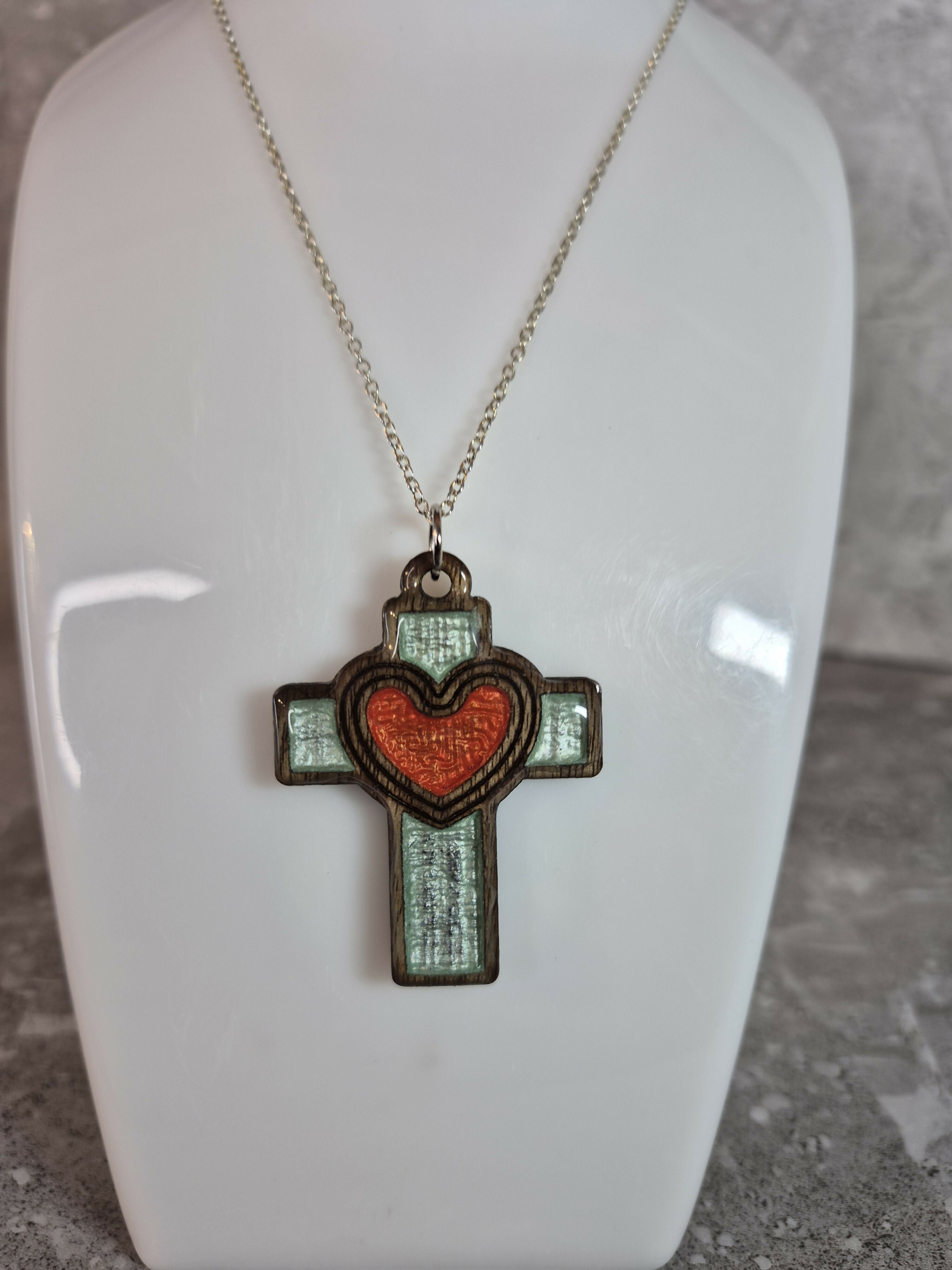 Handcrafted and engraved walnut veneered cross with a heart pendent.