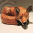 Ceramic curled up fox sculpture