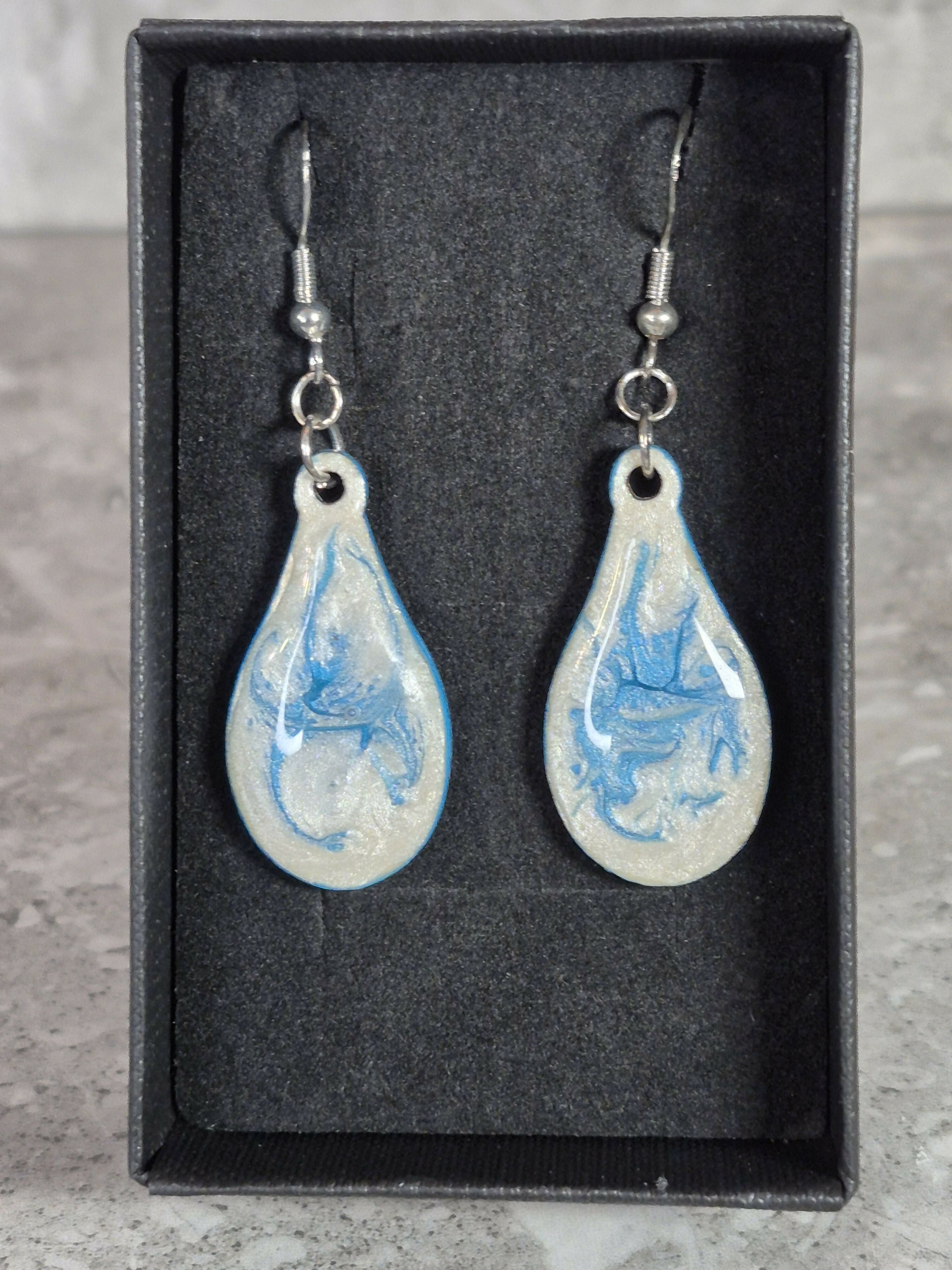 Handcrafted teardrop ivory and cyan colour earrings.