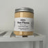 yellow body scrub in a tub on white shelf.
