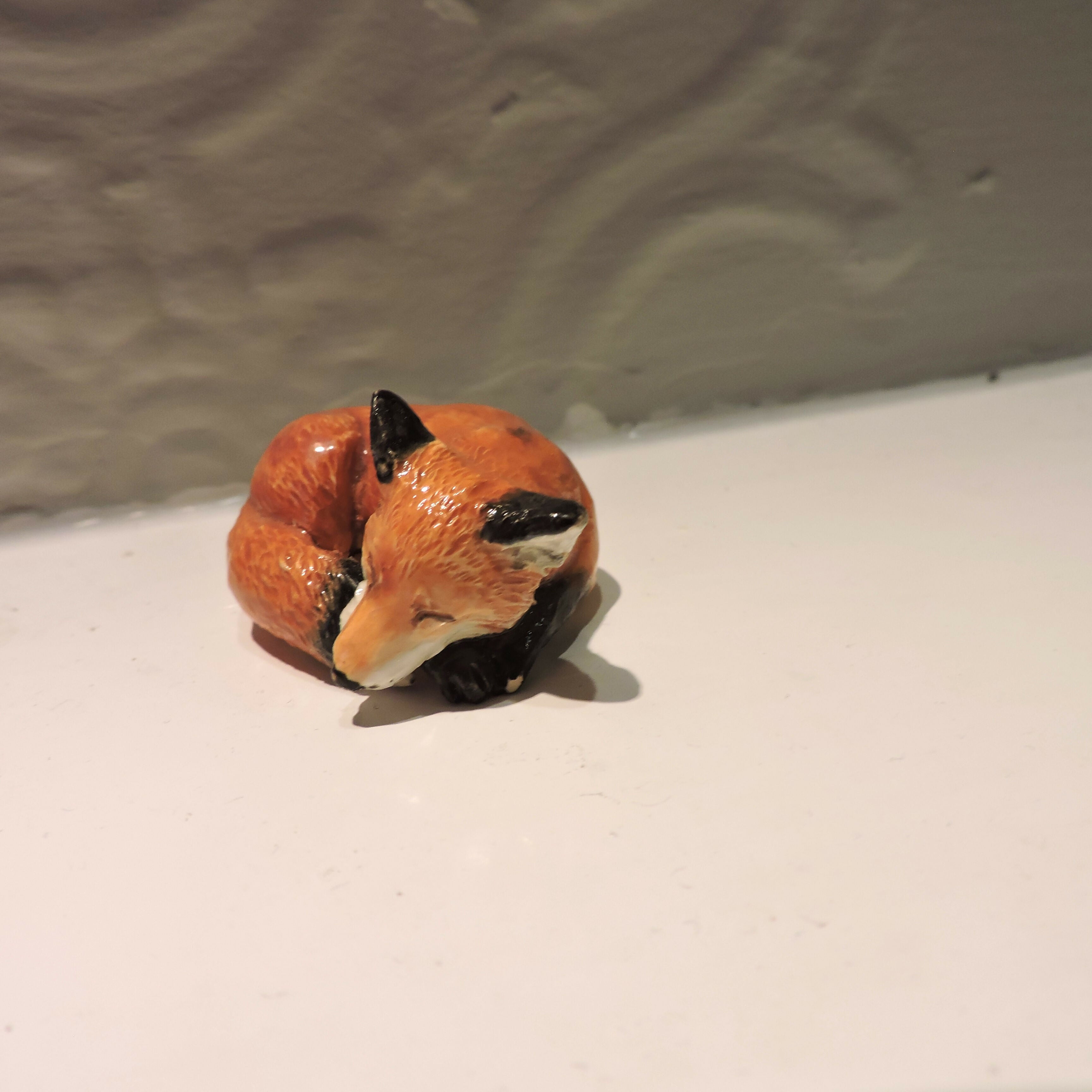 Ceramic sleeping fox sculpture