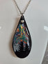 Unique, Hand Crafted, Teardrop Pendant Showing Black Silhouetted Pine Trees Against a Multicoloured Abstract Back Ground Sky