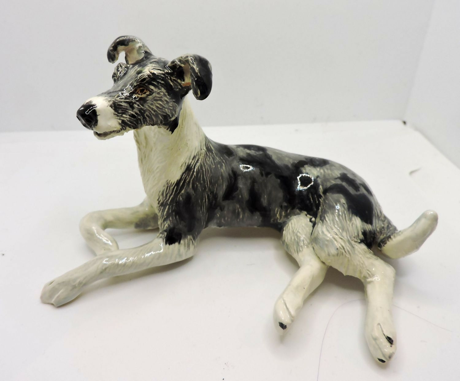 Ceramic Rough coated lurcher dog sculpture, merle