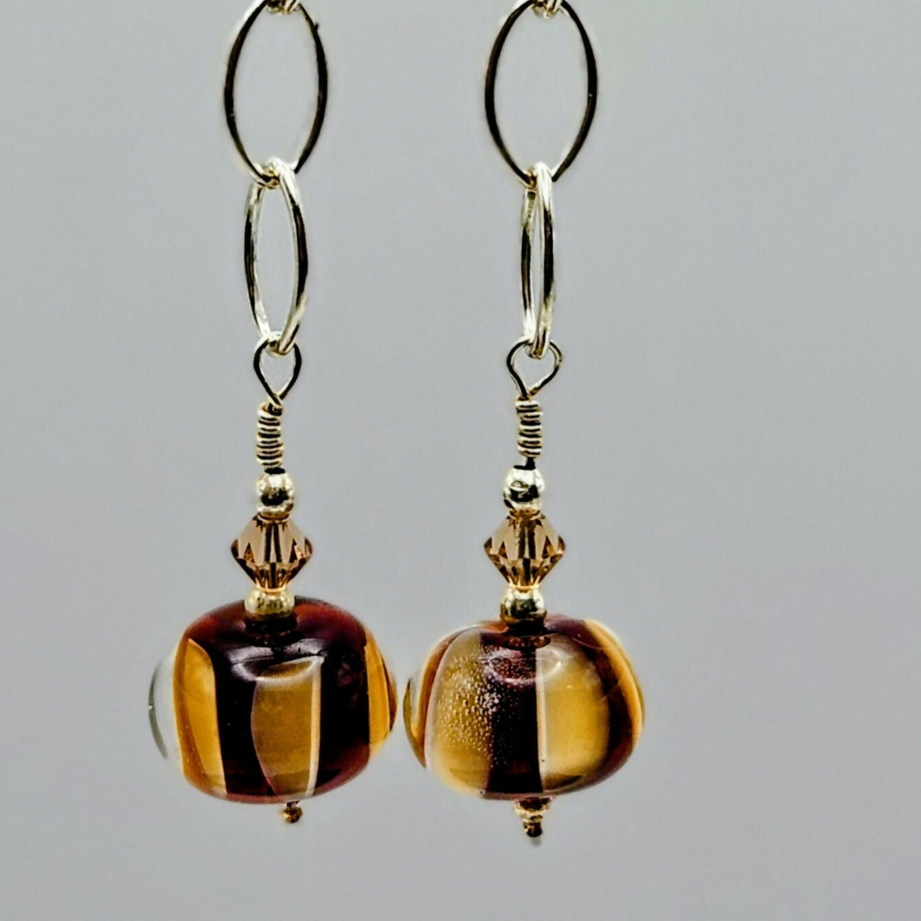 HAND LAMPWORKED GLASS HUMBUG EARRINGS, WITH STERLING SILVER CHAIN , STERLING SILVER EAR WIRES AND SWAROVSKI CRYSTALS.