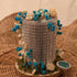 Miniature Blue Floral Arrangement on Wooden Slice.