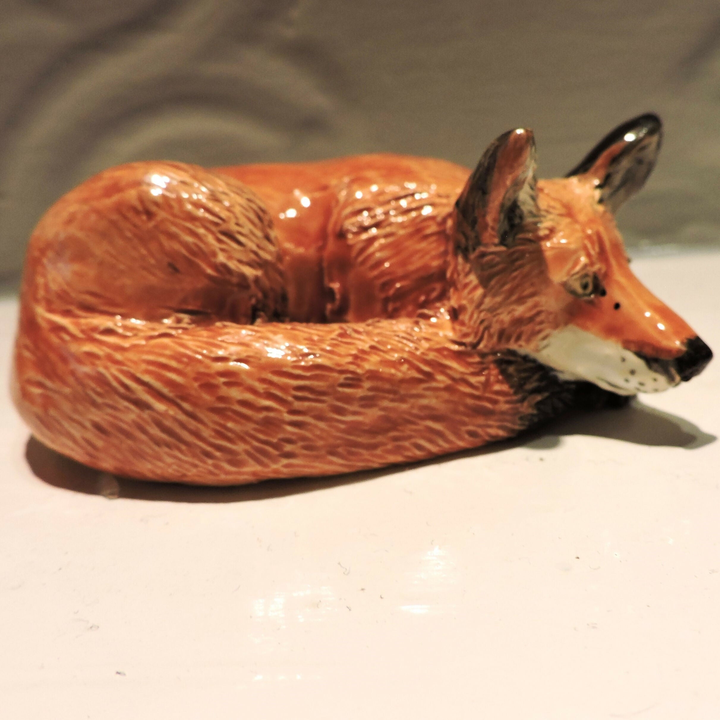 Ceramic curled up fox sculpture