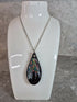Unique, Hand Crafted, Teardrop Pendant Showing Black Silhouetted Pine Trees Against a Multicoloured Abstract Back Ground Sky