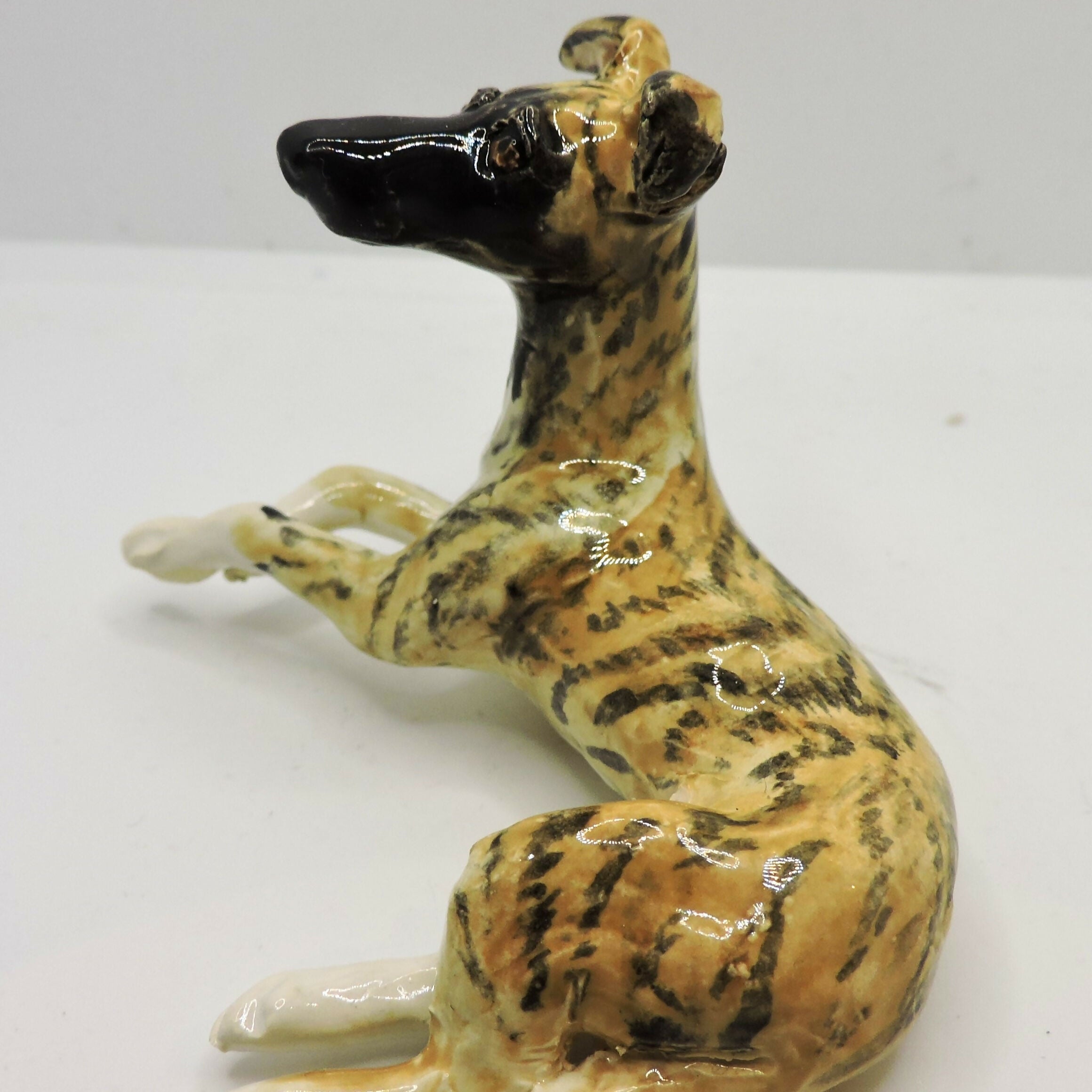 Ceramic lying Whippet dog sculpture, Black mask Brindle