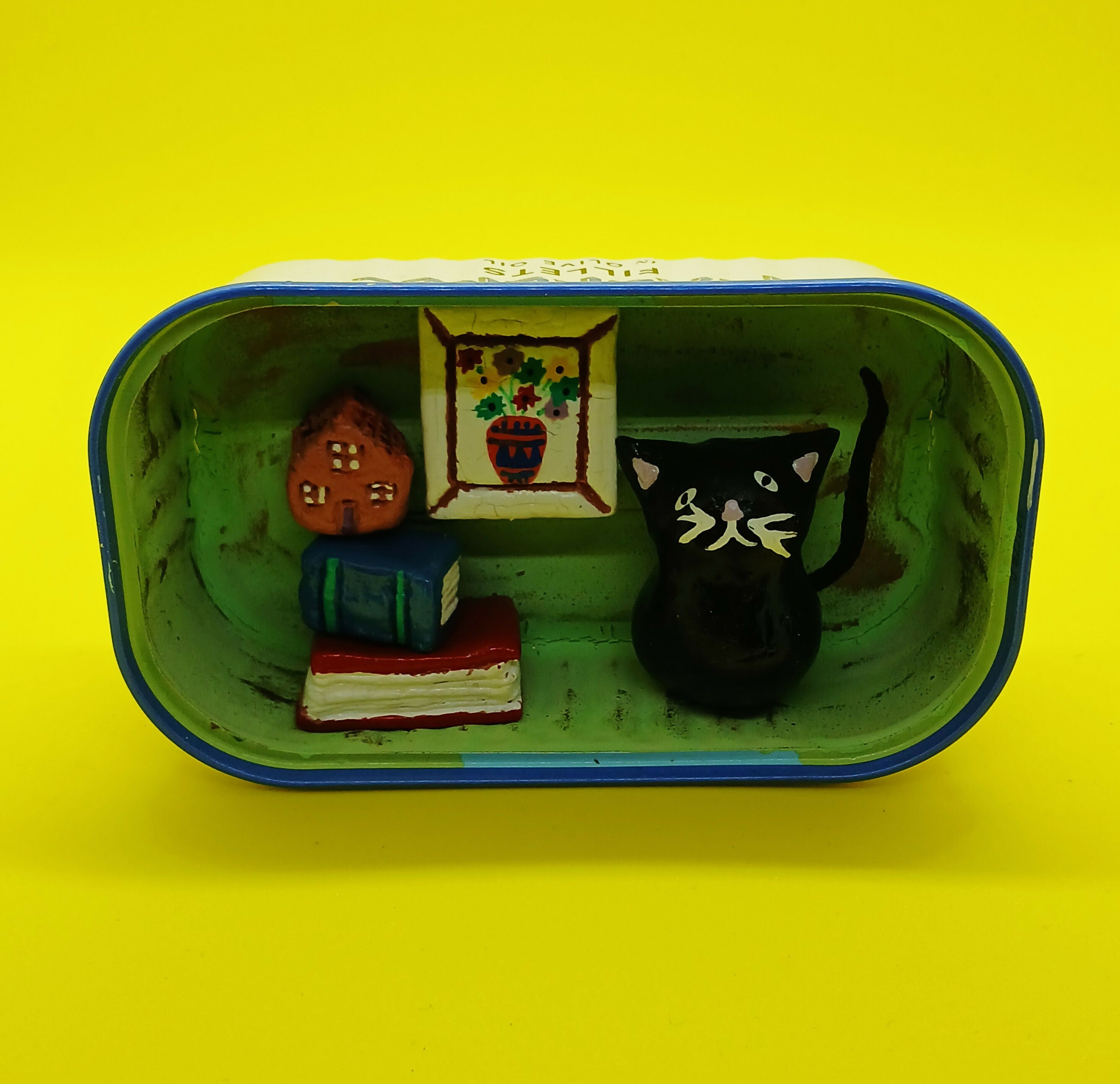 Black Cat with Books and Picture in a Tin