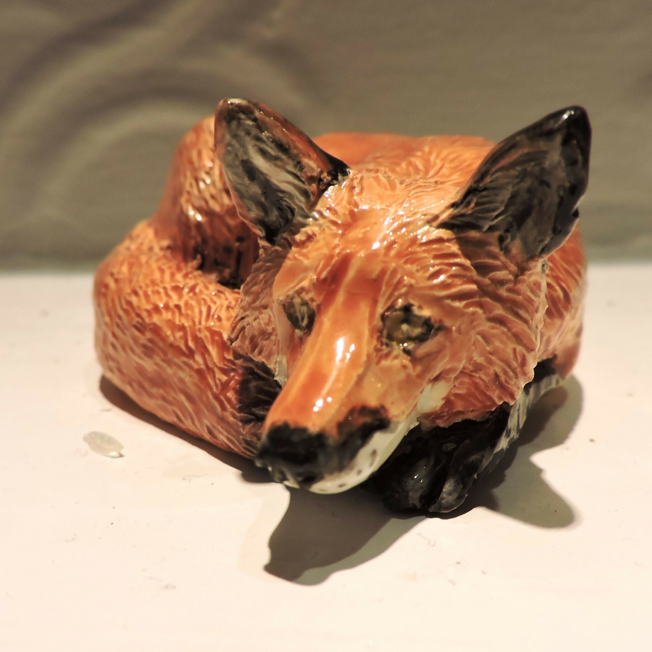 Ceramic curled up fox sculpture