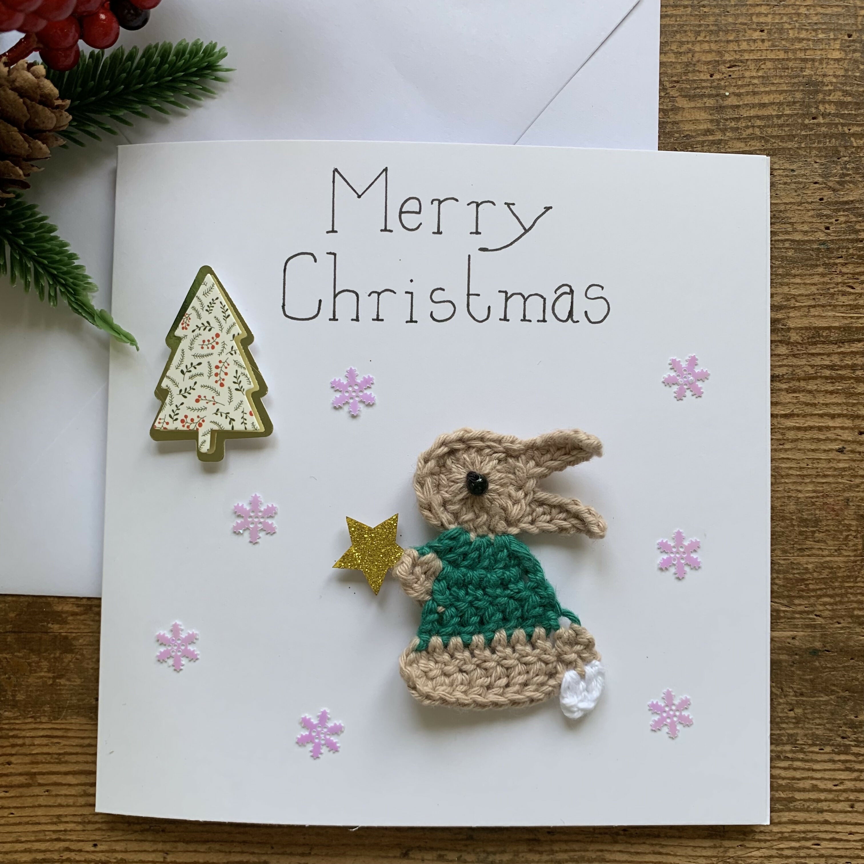 Christmas Card with Crocheted Rabbit Putting Star on the Christmas tree.