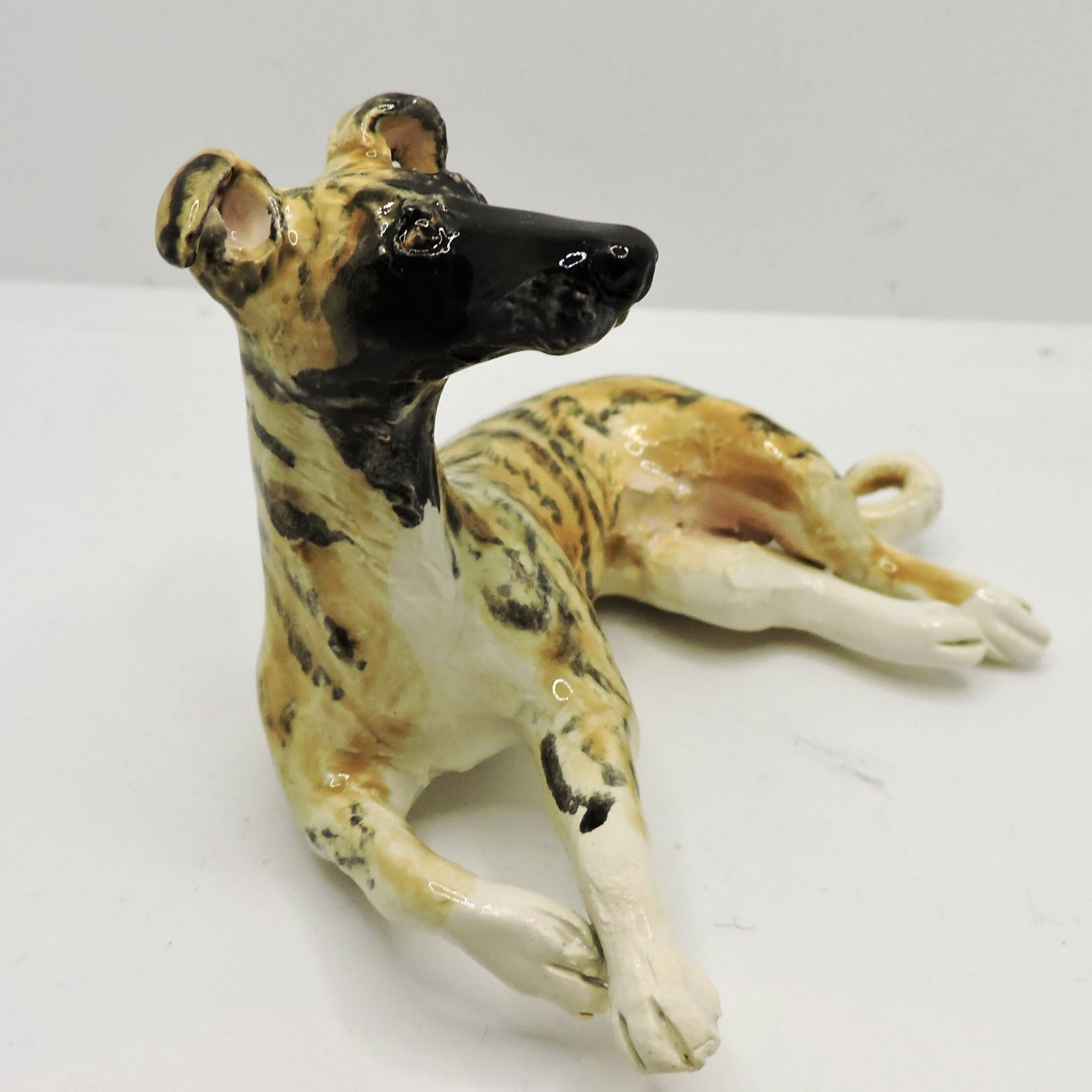 Ceramic lying Whippet dog sculpture, Black mask Brindle