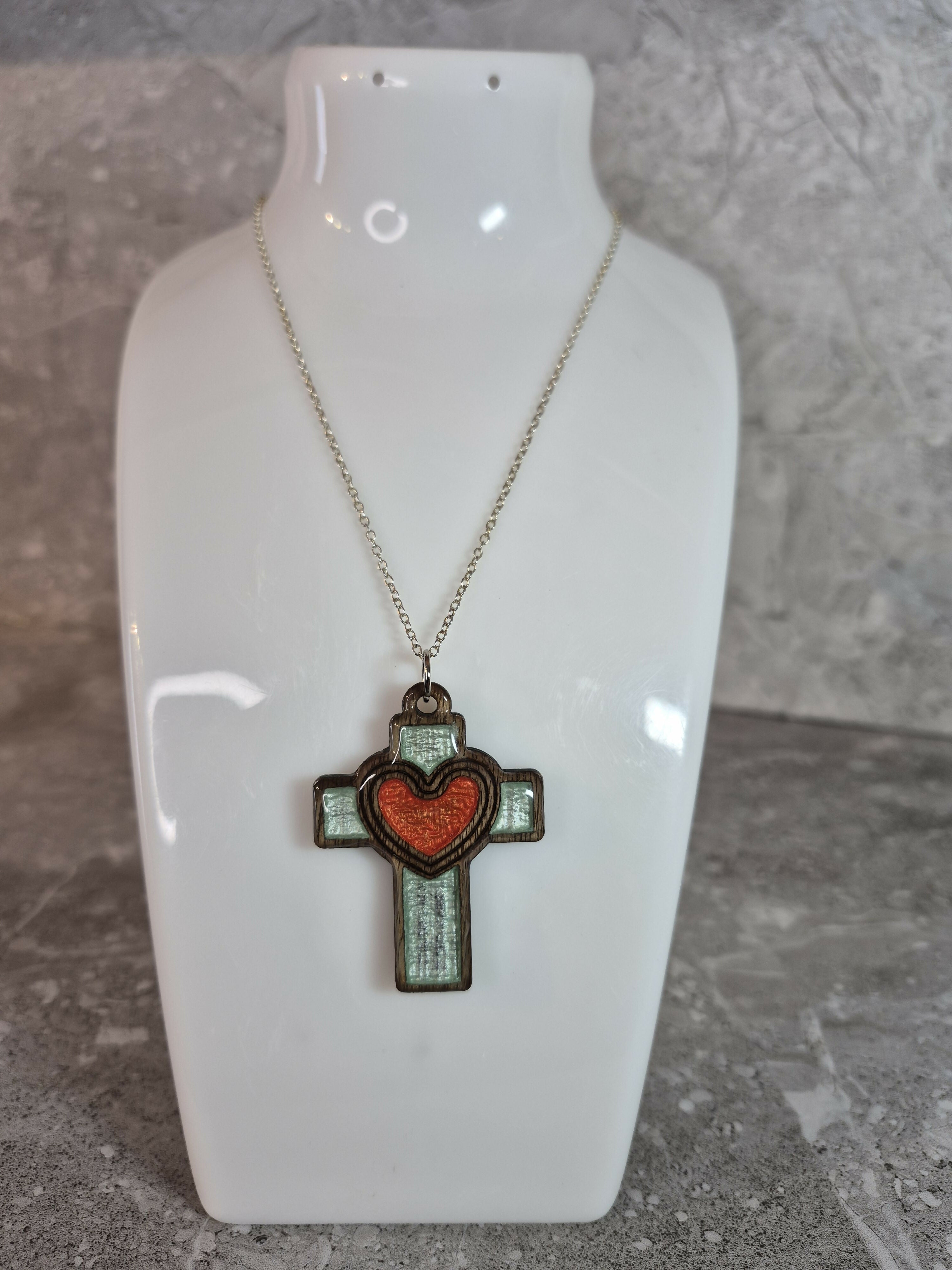 Handcrafted and engraved walnut veneered cross with a heart pendent.
