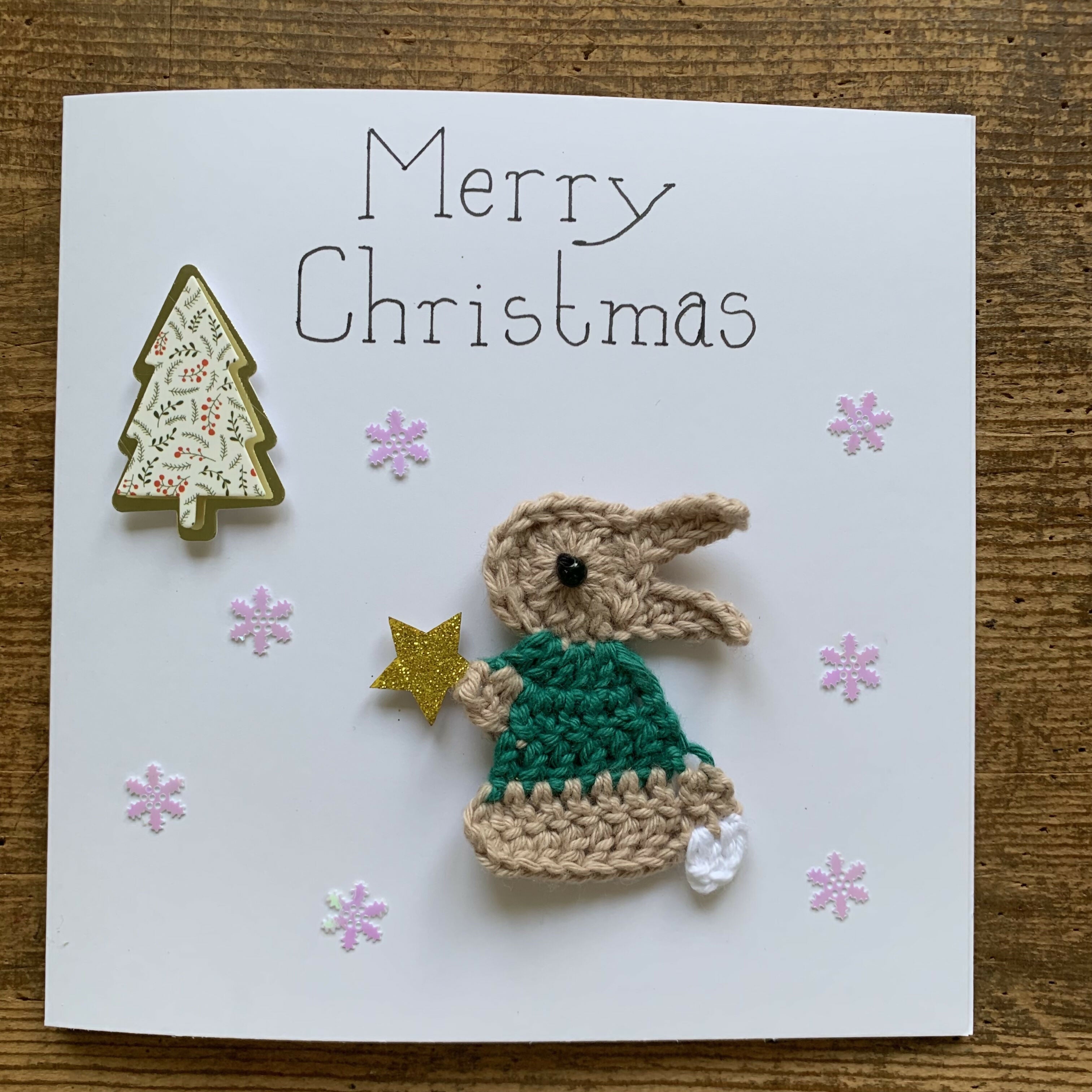 Christmas Card with Crocheted Rabbit Putting Star on the Christmas tree.
