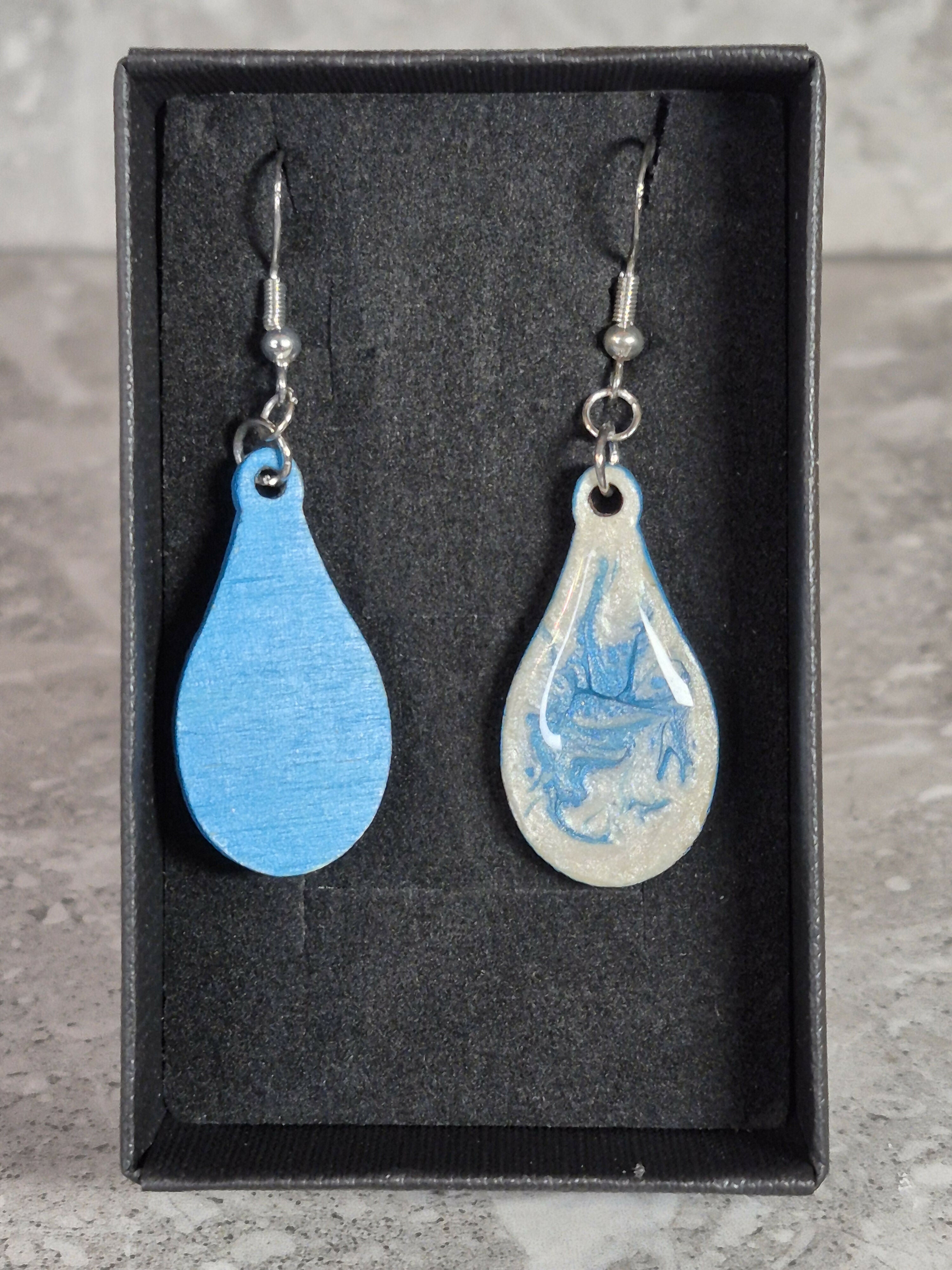 Handcrafted teardrop ivory and cyan colour earrings.