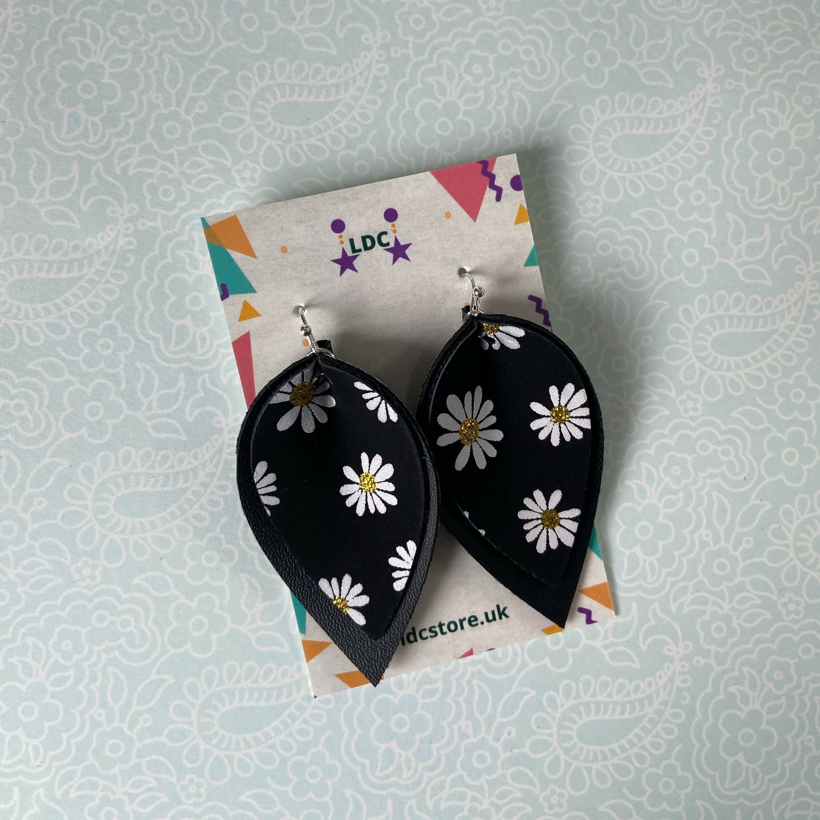 Daisy Print and Black Pinched Leaf Shaped Earrings in Faux Leather